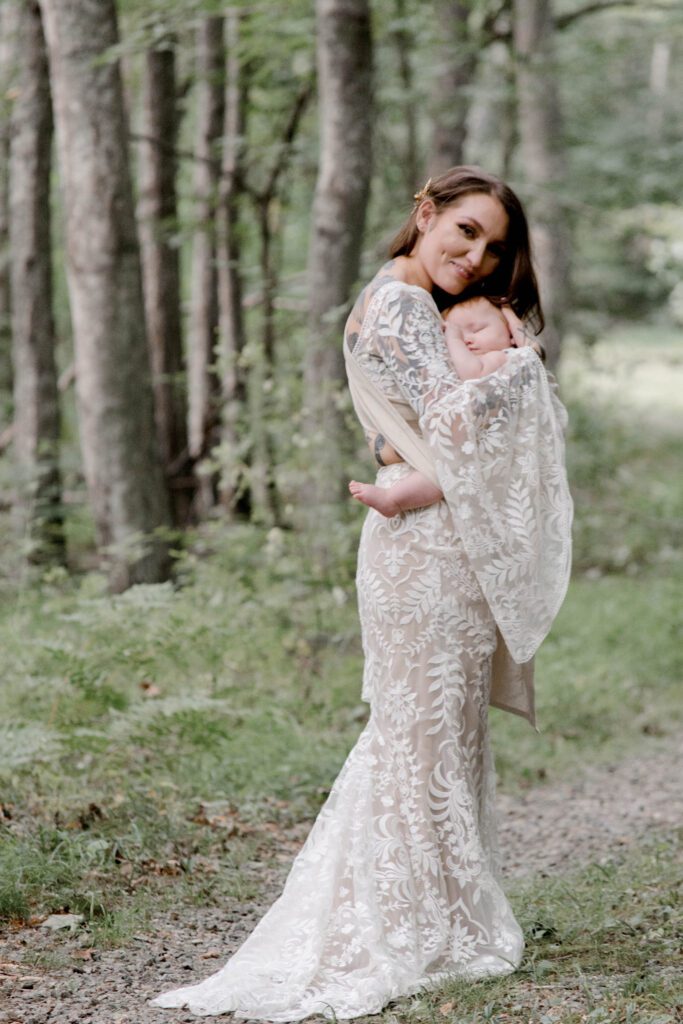 Bride with baby in woods.