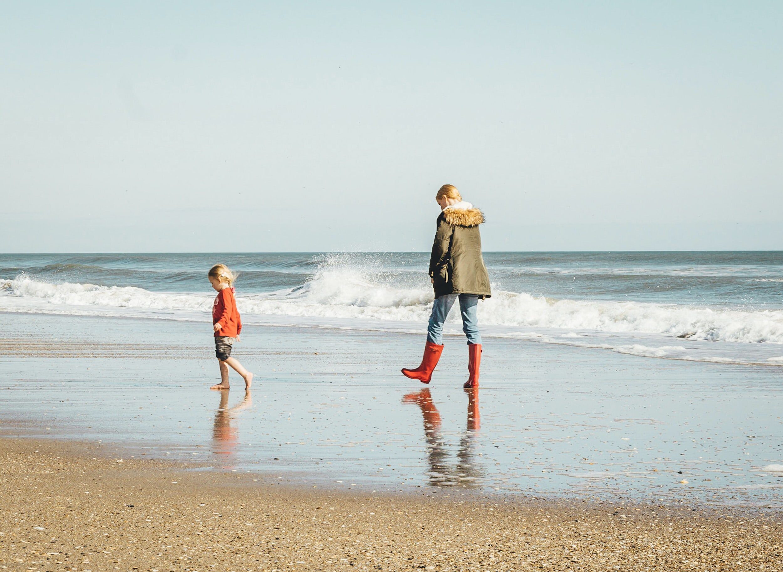 mother and daughter walking on beach