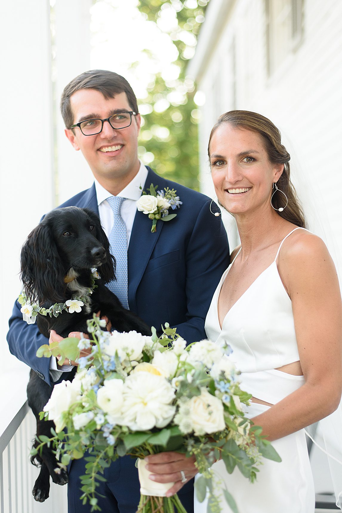 Bride and groom, posing with dog.